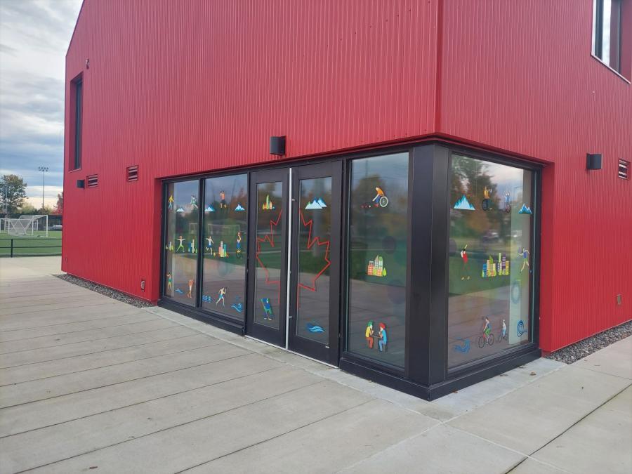 Cartoon decals on a window of a red building at a park