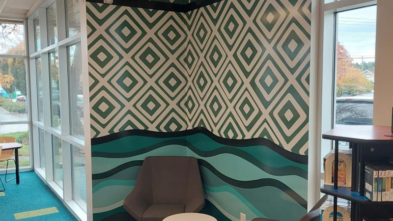 Green and white triangular artwork in the corner of a library
