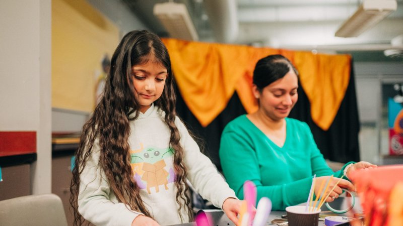 Two females making wearable art.
