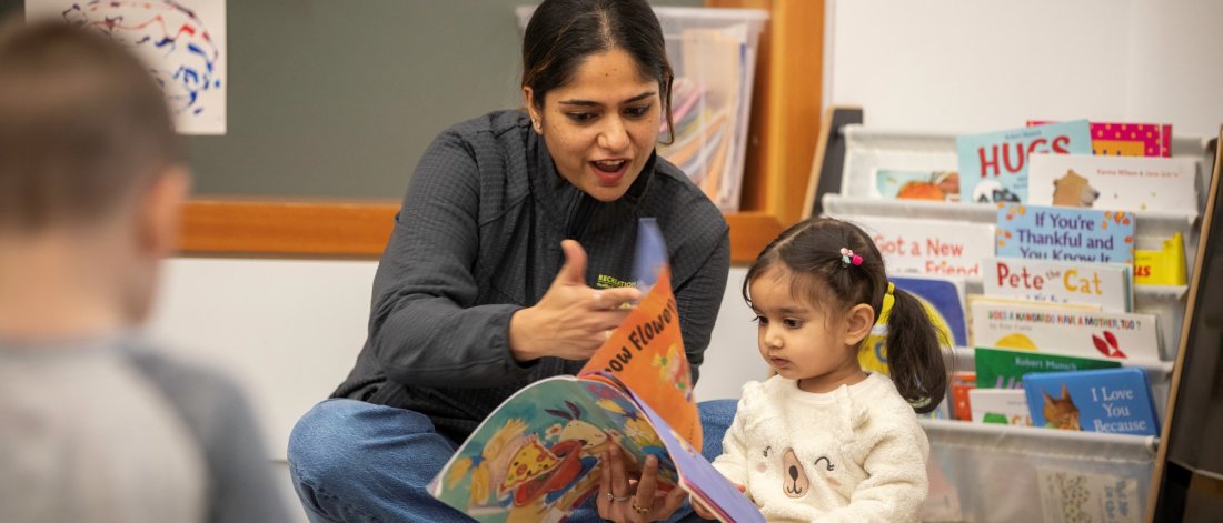 Preschool teacher reading with child