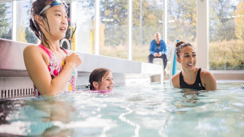 Children and swimming instructor in the pool.