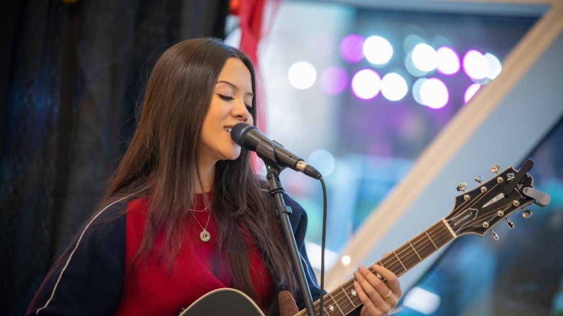 performer on stage with guitar
