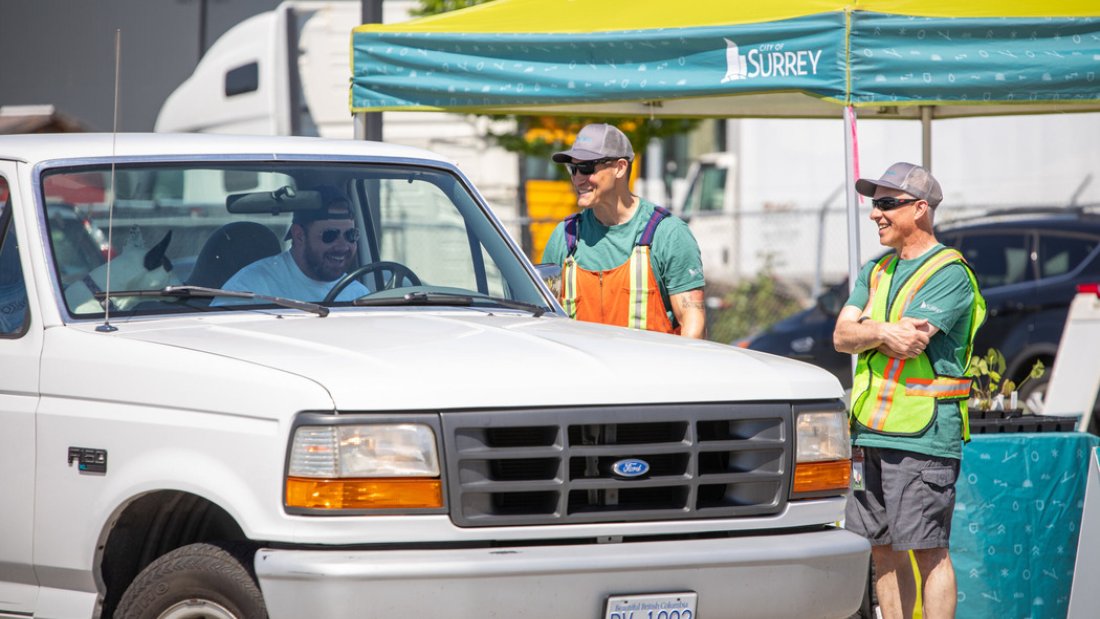 a greeter welcomes residents into the lot at the tree sale